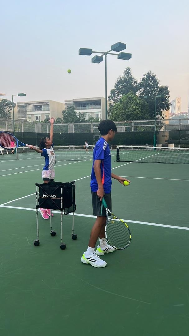 Players practising tennis on an outdoor court